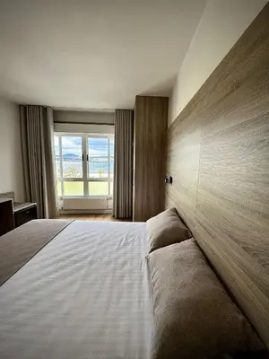 a bedroom with a large bed with a large window at Miramar Suites in Sada