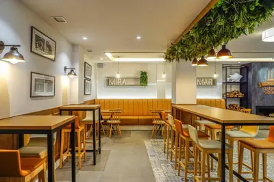 a restaurant with tables and chairs and a bench at Miramar Suites in Sada
