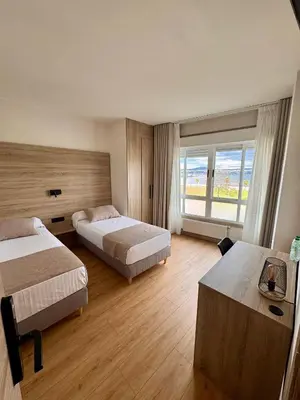 a hotel room with two beds and a large window at Miramar Suites in Sada