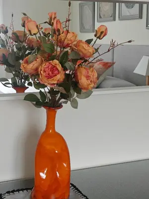 an orange vase with flowers in it on a table at Apartamento casa Chilin in Sarria