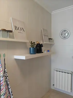 a room with shelves and a clock on the wall at Apartamento casa Chilin in Sarria