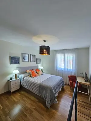 a bedroom with a bed and a red chair at Apartamento casa Chilin in Sarria