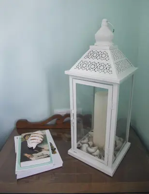 a white lantern sitting on a table with a magazine at A Casa do Porto in Burela de Cabo