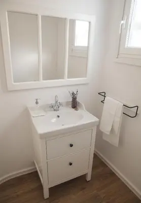 a white bathroom with a sink and a mirror at A Casa do Porto in Burela de Cabo