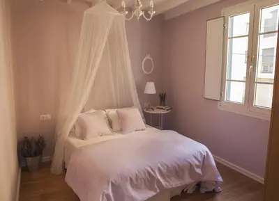 a bedroom with a canopy bed with pink pillows at A Casa do Porto in Burela de Cabo