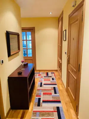 a living room with a table and a rug on the floor at apartamento céntrico y fabuloso en Ribadeo para vacaciones in Ribadeo