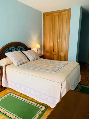 a bedroom with a large bed and a table at apartamento céntrico y fabuloso en Ribadeo para vacaciones in Ribadeo