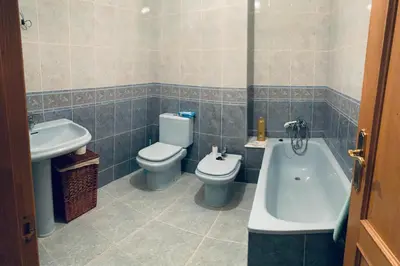 a bathroom with a toilet and a tub and a sink at apartamento céntrico y fabuloso en Ribadeo para vacaciones in Ribadeo