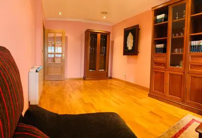 a living room with wooden floors and wooden cabinets at apartamento céntrico y fabuloso en Ribadeo para vacaciones in Ribadeo