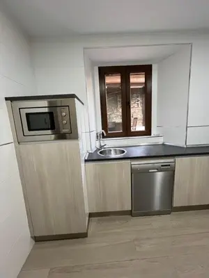 a kitchen with a sink and a microwave at Casa Victoriano in Melide
