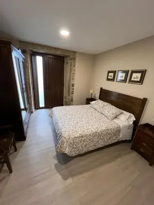 a bedroom with a bed and a wooden floor at Casa Victoriano in Melide