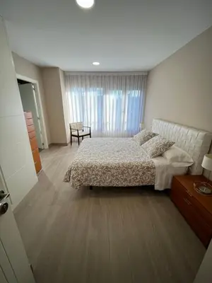 a bedroom with a bed and a large window at Casa Victoriano in Melide