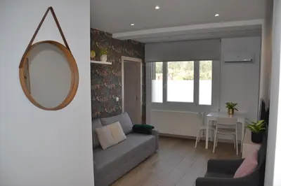 a living room with a couch and a mirror at Avío Apartamentos in Santiago de Compostela