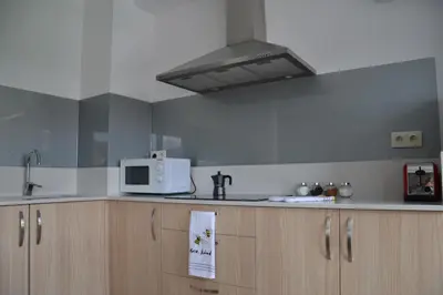 a kitchen with a white microwave and wooden cabinets at Avío Apartamentos in Santiago de Compostela