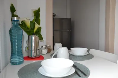 a table with plates and bowls and a vase at Avío Apartamentos in Santiago de Compostela