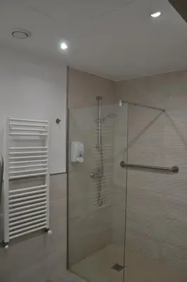 a bathroom with a shower with a glass door at Avío Apartamentos in Santiago de Compostela