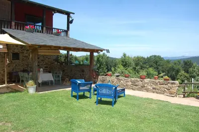 two blue chairs sitting in the yard of a house at Nuevo sabor rural Ribeira Sacra in A Pobra do Brollon