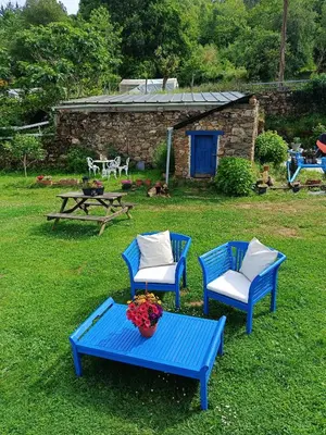 two blue chairs and a table in a yard at Nuevo sabor rural Ribeira Sacra in A Pobra do Brollon