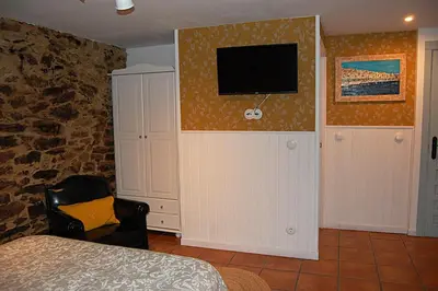 a bedroom with a bed and a television on a wall at Nuevo sabor rural Ribeira Sacra in A Pobra do Brollon