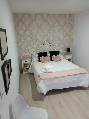 a bedroom with a white bed with two pink pillows at Él Rincón de los Sueños A in Vegadecabo