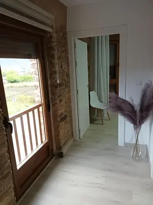 a hallway with a wooden door and a window at Él Rincón de los Sueños A in Vegadecabo