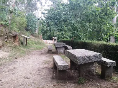 a group of stone benches sitting on a dirt road at Apartamentos A Palleira in Barreiros