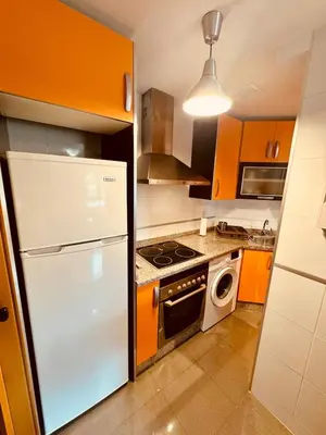 a kitchen with orange cabinets and a white refrigerator at House Borba Foz in Foz