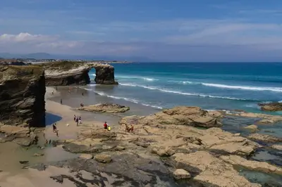 a group of people on a beach with an arch in the ocean at Tranquilidad cerca de playas y lugares históricos VUT-LU-00402 in Lourenzá