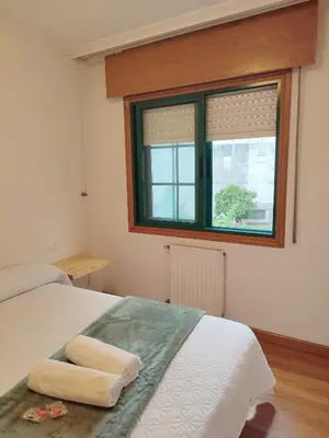 a bedroom with a bed and a window at Pensión Armonía in Caldas de Reis