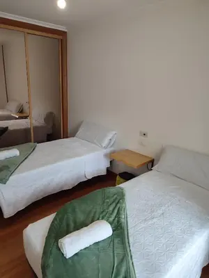 a hotel room with two beds and a mirror at Pensión Armonía in Caldas de Reis