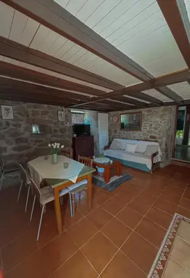 a living room with a bed and a table and chairs at A Palleira in San Amaro