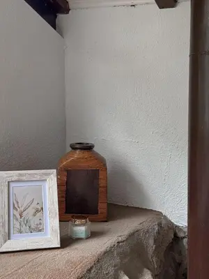 a wooden jar sitting on a shelf next to a picture at A Palleira in San Amaro