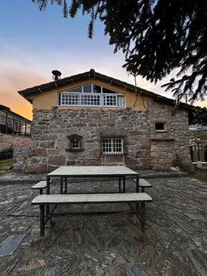 a bench sitting in front of a stone building at A Palleira in San Amaro