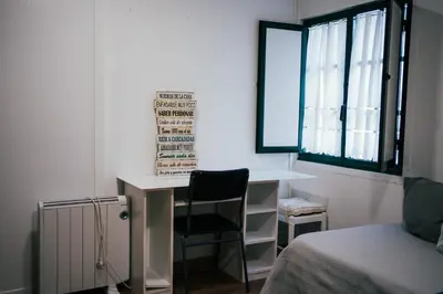 a bedroom with a desk and a chair next to a bed at Casa Milladoiro in Miño