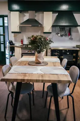 a kitchen with a wooden table with chairs around it at Casa Milladoiro in Miño