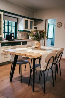 a table with chairs and a vase of flowers on it at Casa Milladoiro in Miño