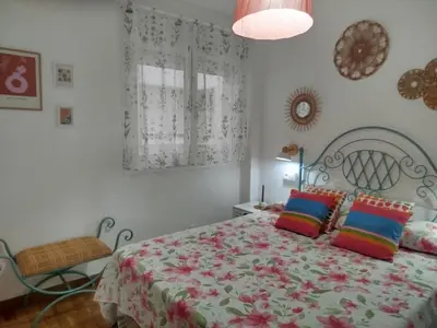 a bedroom with a large bed with colorful pillows at El Valle in San Cosme de Barreiros