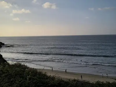 a group of people walking on the beach at El Valle in San Cosme de Barreiros