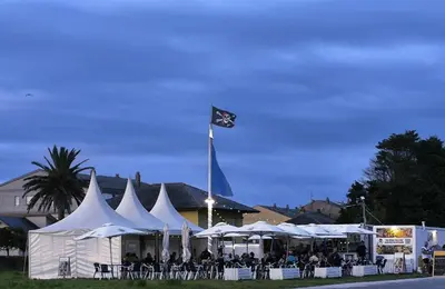 a group of white tents with people sitting under them at El Valle in San Cosme de Barreiros