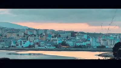 a view of a city with blue buildings and a beach at El Valle in San Cosme de Barreiros