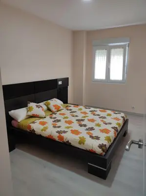 a bedroom with a bed with a comforter and pillows at Piso en Valadouro in Valle de Oro