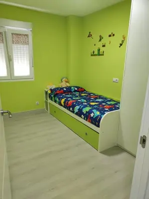 a bedroom with a bed in a room with green walls at Piso en Valadouro in Valle de Oro