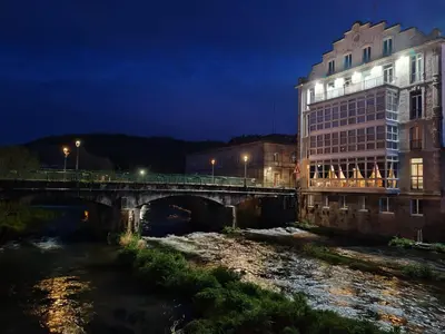 a bridge over a river at night with a building at Loft Luxury in Caldas de Reis