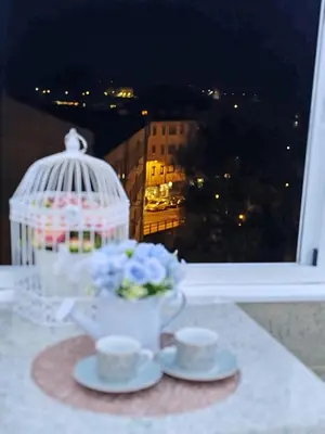 a table with two cups of tea and a bird cage at Loft Luxury in Caldas de Reis