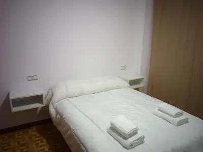 a white bed with two towels on top of it at Adrian in Arzúa