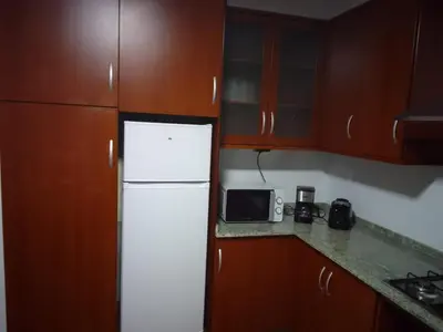 a kitchen with a white refrigerator and wooden cabinets at Adrian in Arzúa