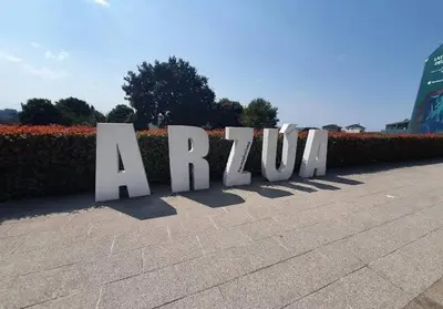 a large white sign that says a rhino at Adrian in Arzúa
