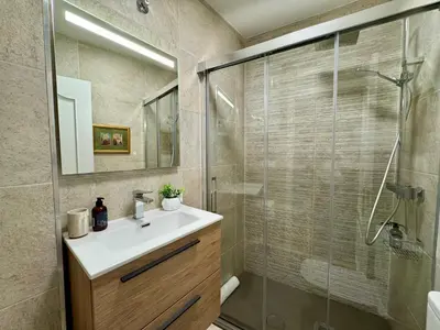 a bathroom with a sink and a glass shower at Bulebule - Acogedor apartamento en pleno centro de Ourense in Ourense