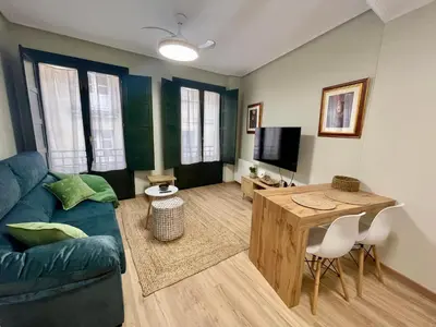 a living room with a blue couch and a table at Bulebule - Acogedor apartamento en pleno centro de Ourense in Ourense