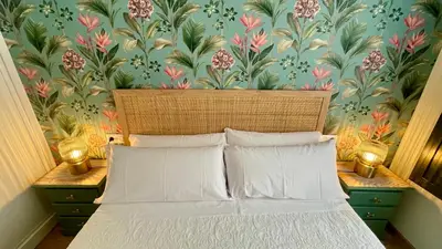 a bedroom with a bed with a floral wallpaper at Bulebule - Acogedor apartamento en pleno centro de Ourense in Ourense